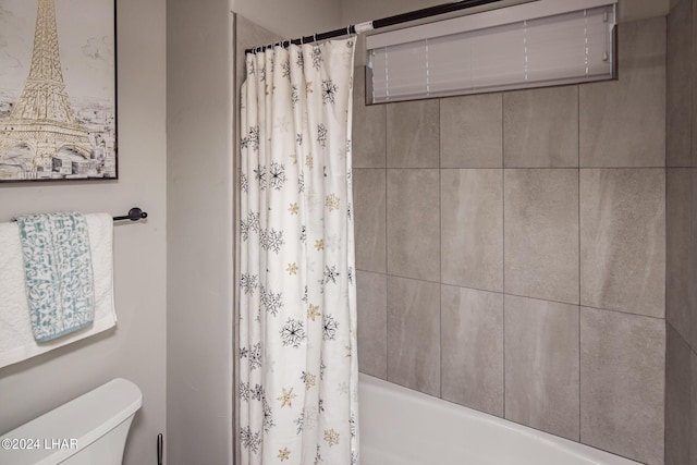 bathroom featuring shower / tub combo with curtain and toilet