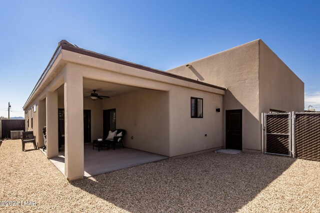 rear view of property featuring ceiling fan and a patio area