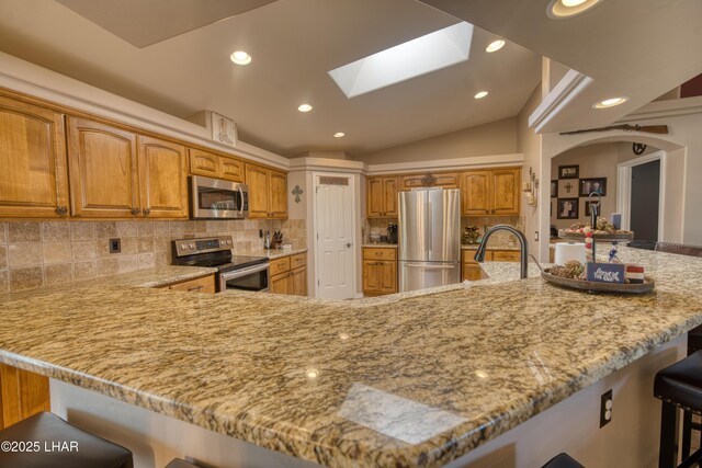 1430 Murphy Dr, Lake Havasu City, AZ 86404 - kitchen with stainless steel appliances, a breakfast bar, a skylight, recessed lighting, and decorative backsplash