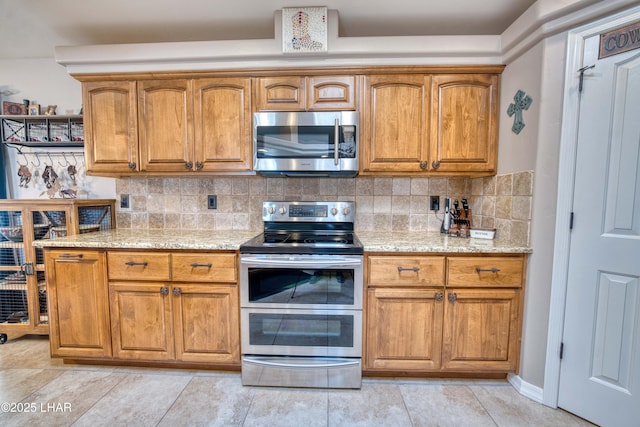 1430 Murphy Dr, Lake Havasu City, AZ 86404 - kitchen with stainless steel appliances, light stone counters, brown cabinets, and tasteful backsplash