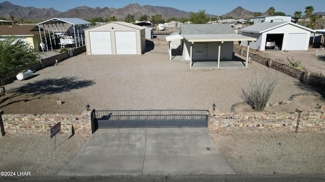 view of front of house featuring an outbuilding, a mountain view, a garage, and a carport