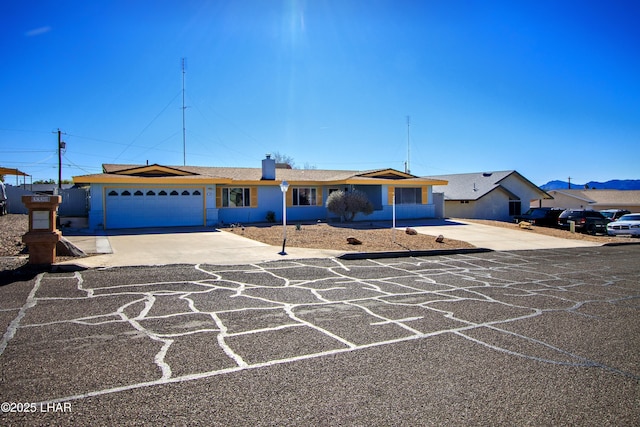 single story home with a garage, driveway, and stucco siding