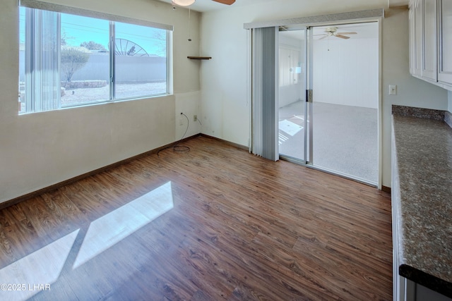 unfurnished room featuring ceiling fan, baseboards, and wood finished floors