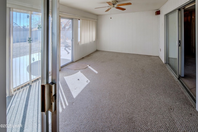 unfurnished sunroom with a ceiling fan