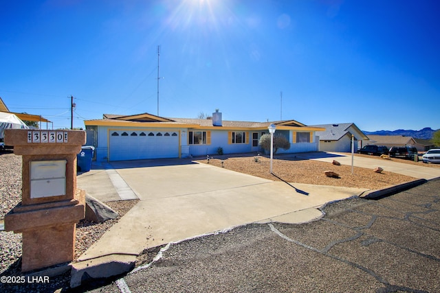 single story home with a garage, driveway, and a mountain view