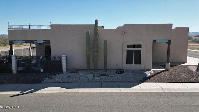 exterior space with fence, a balcony, and stucco siding