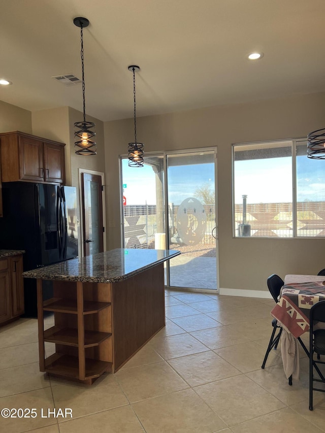 kitchen featuring visible vents, plenty of natural light, dark stone countertops, and open shelves