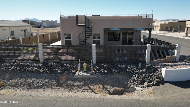 view of front of property with stairs, a fenced front yard, a residential view, and stucco siding