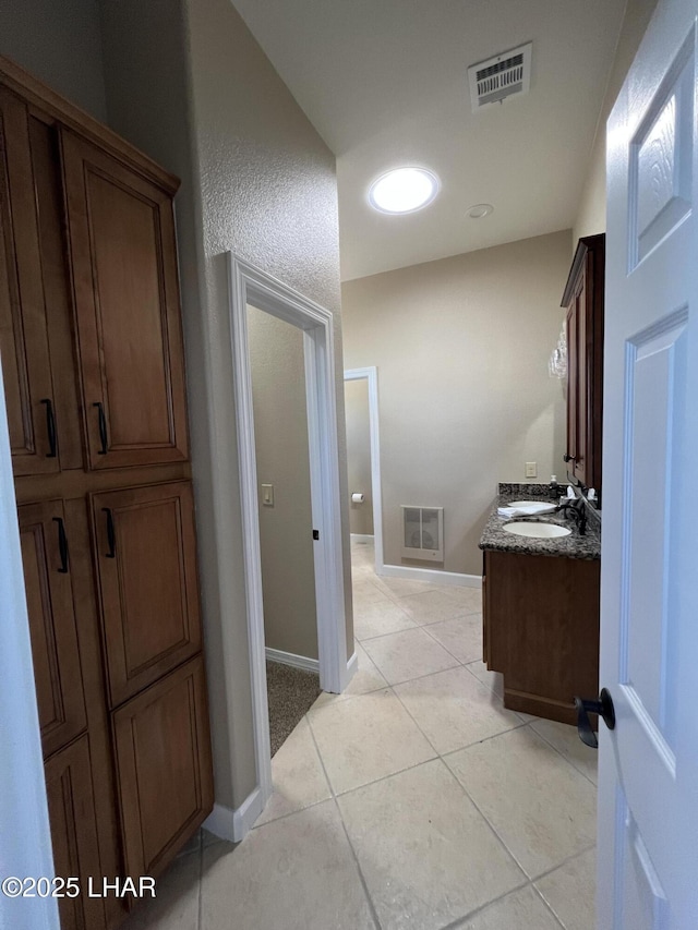 bathroom with tile patterned floors, baseboards, visible vents, and vanity