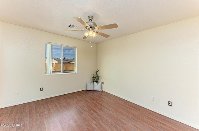 empty room featuring ceiling fan, light hardwood / wood-style floors, and a textured ceiling