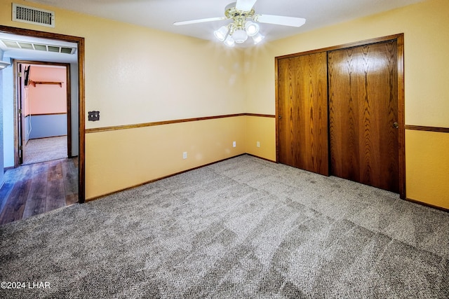 unfurnished bedroom featuring a closet, ceiling fan, and dark colored carpet