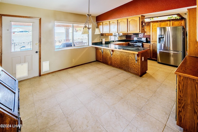 kitchen with sink, a breakfast bar, appliances with stainless steel finishes, decorative light fixtures, and kitchen peninsula