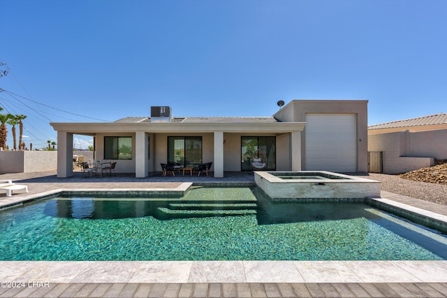 view of swimming pool featuring an in ground hot tub, central AC unit, and a patio