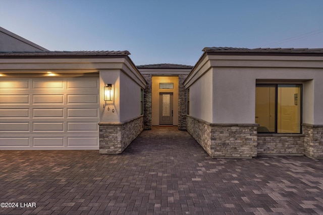 exterior entry at dusk with a garage