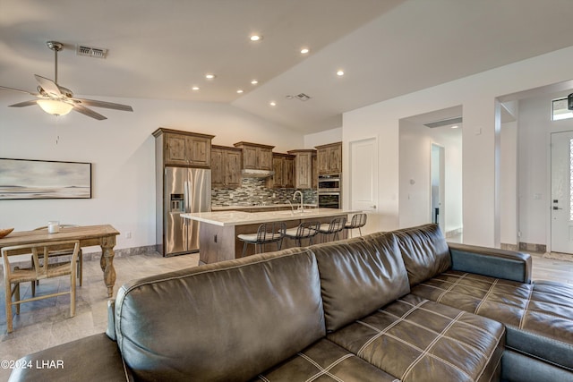 living room with vaulted ceiling, sink, and ceiling fan