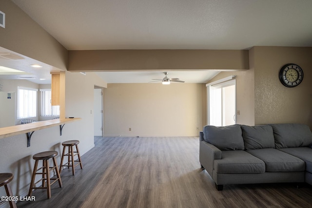 living room with hardwood / wood-style flooring, ceiling fan, and lofted ceiling