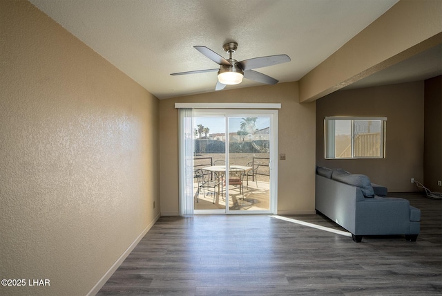 doorway to outside featuring ceiling fan, dark wood-type flooring, a textured ceiling, and lofted ceiling