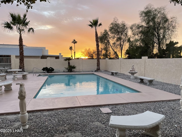 pool at dusk featuring a patio area