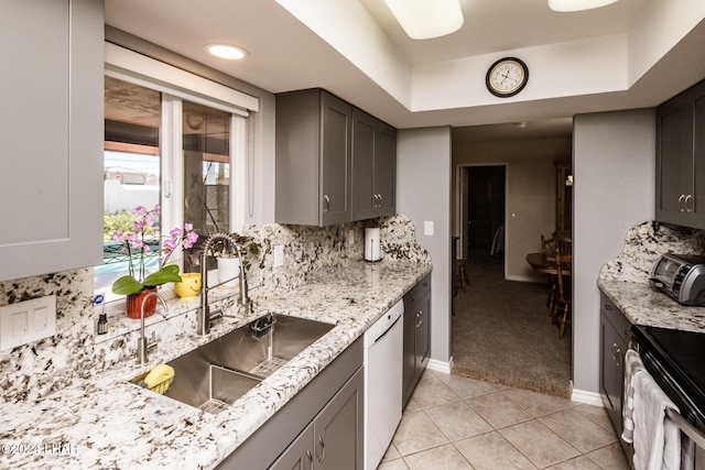 kitchen with sink, tasteful backsplash, light tile patterned floors, electric range, and dishwasher