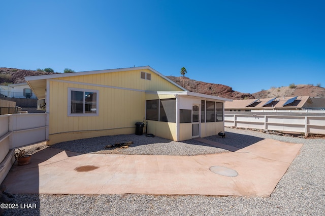 37339 Buckskin Cir, Parker, AZ 85344 - back of house featuring a sunroom, a mountain view, a fenced backyard, and a patio