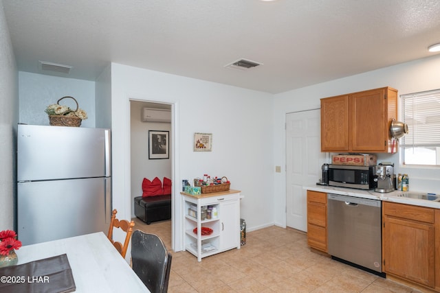 37339 Buckskin Cir, Parker, AZ 85344 - kitchen featuring stainless steel appliances, light countertops, a wall mounted AC, and brown cabinetry