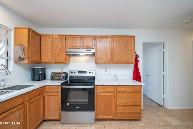 37339 Buckskin Cir, Parker, AZ 85344 - kitchen featuring stainless steel electric range, under cabinet range hood, light countertops, a sink, and light tile patterned flooring