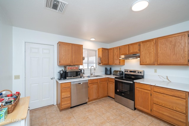 37339 Buckskin Cir, Parker, AZ 85344 - kitchen with appliances with stainless steel finishes, a sink, light countertops, under cabinet range hood, and light tile patterned flooring
