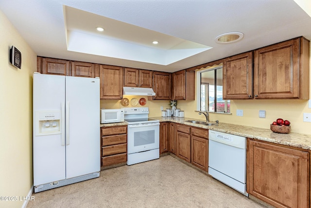 kitchen featuring brown cabinets, white appliances, a sink, and under cabinet range hood