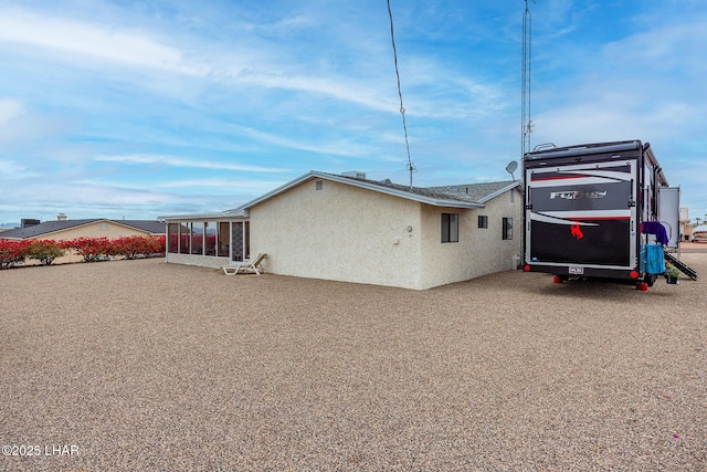 view of home's exterior featuring a sunroom and stucco siding