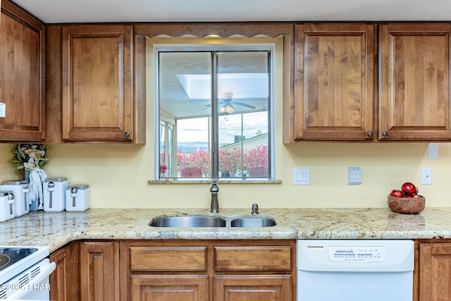 kitchen featuring ceiling fan, white appliances, brown cabinetry, and a sink