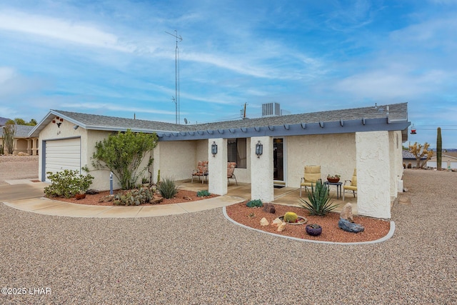 ranch-style house featuring central AC unit, an attached garage, a shingled roof, and stucco siding