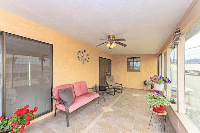 sunroom / solarium featuring ceiling fan