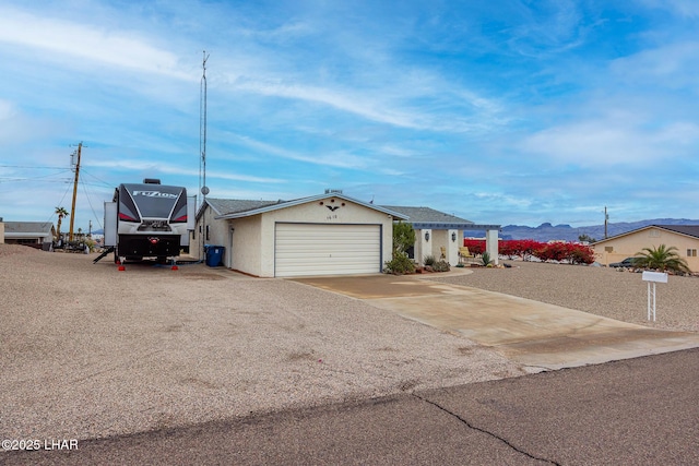 view of front facade featuring a garage, concrete driveway, and stucco siding