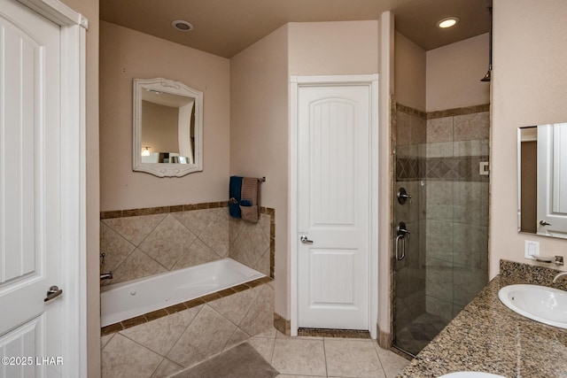 bathroom featuring double vanity, a sink, a shower stall, tile patterned flooring, and a bath