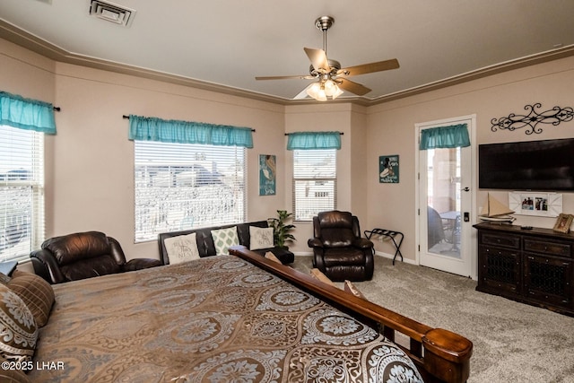 bedroom with ceiling fan, carpet flooring, visible vents, baseboards, and crown molding