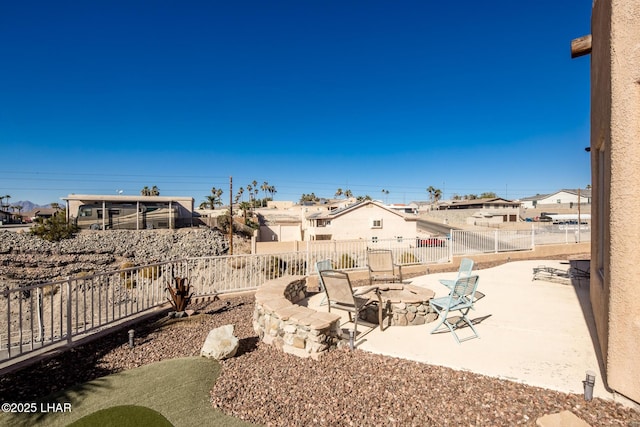 view of yard featuring an outdoor fire pit, a residential view, fence, and a patio