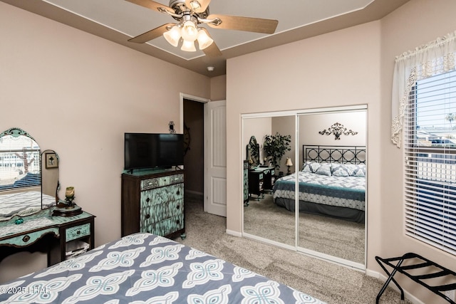 carpeted bedroom with a closet, a ceiling fan, and baseboards