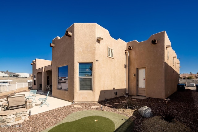 back of property featuring a patio area, fence, and stucco siding