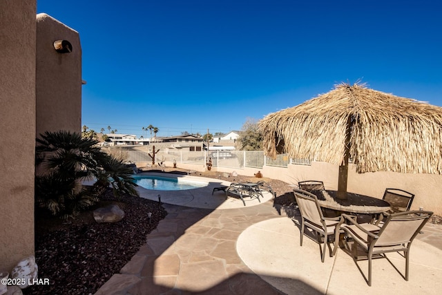 view of patio / terrace featuring outdoor dining area, fence, and a fenced in pool