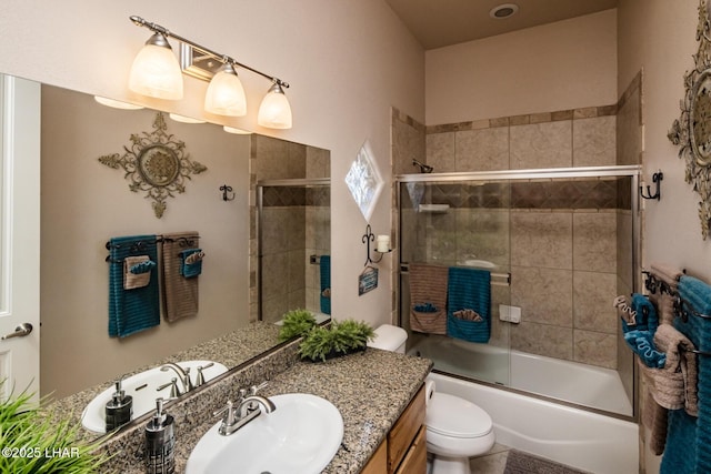 full bath featuring shower / bath combination with glass door, vanity, and toilet