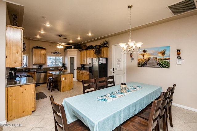 dining space with light tile patterned floors, visible vents, crown molding, and ceiling fan with notable chandelier