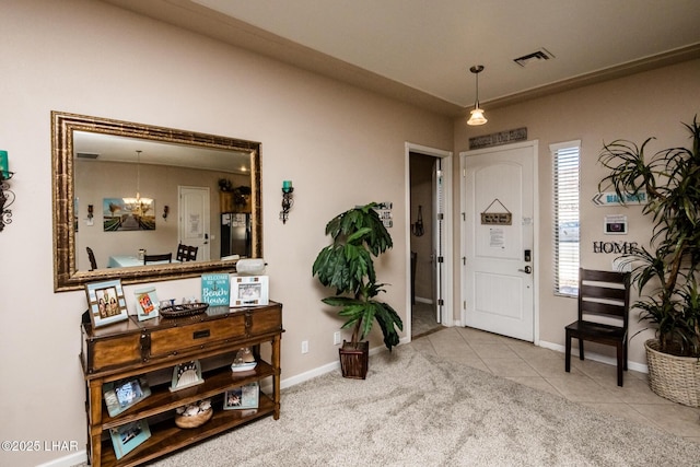 entrance foyer with light tile patterned floors, light colored carpet, visible vents, a chandelier, and baseboards