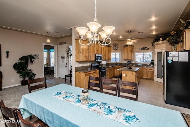 dining space featuring light tile patterned flooring, ceiling fan with notable chandelier, visible vents, baseboards, and ornamental molding