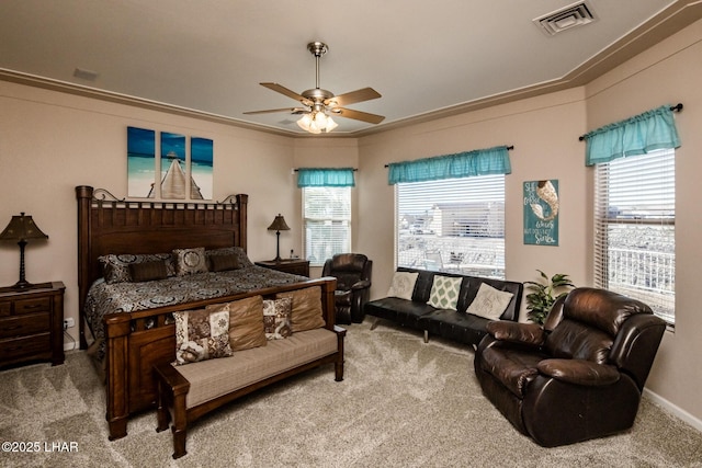 bedroom with a ceiling fan, visible vents, crown molding, and light colored carpet