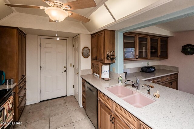 kitchen featuring sink, light tile patterned floors, ceiling fan, light stone countertops, and stainless steel dishwasher