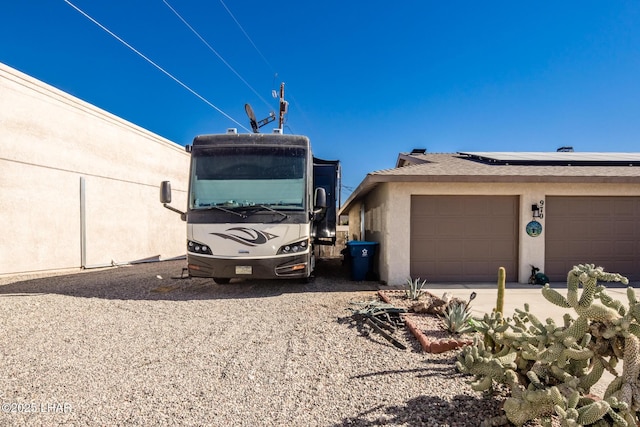 view of side of home featuring a garage and solar panels