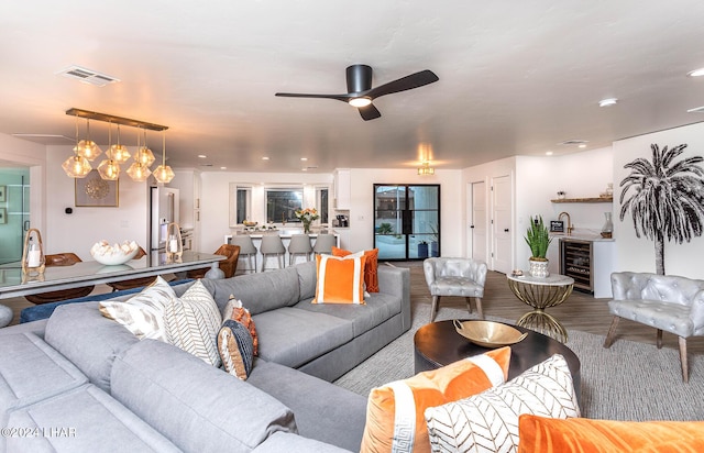 living area featuring visible vents, beverage cooler, a ceiling fan, wood finished floors, and recessed lighting