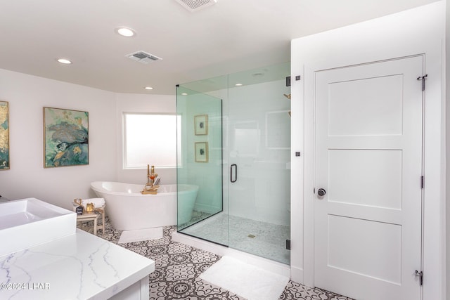 bathroom with vanity, visible vents, a stall shower, a freestanding bath, and tile patterned flooring