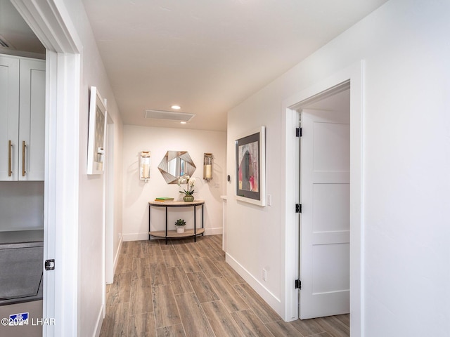 hall with recessed lighting, attic access, baseboards, and wood finished floors