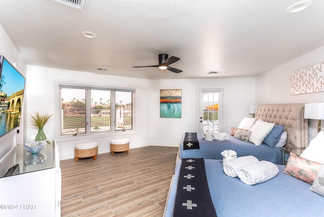 bedroom with multiple windows, baseboards, and light wood finished floors